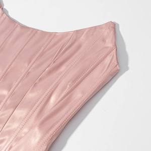 Close-up of pink satin corset top showing vertical boning structure and quilted fabric