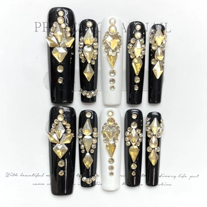 Luxurious long coffin press-on nails in black and white with champagne gold rhinestones