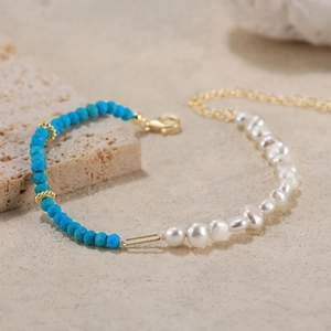 925 silver bracelet with turquoise beads and natural freshwater pearls on stone surface