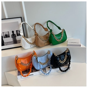 Detail of trendy crescent underarm bags with woven handles and decorative gold chains