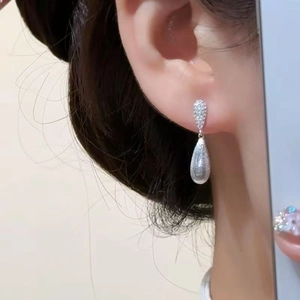 Elegant silver drop earrings with zircons shown on a model for a stylish commute look