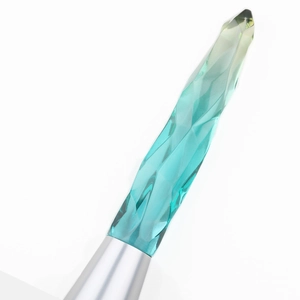 Macro view of a multifaceted crystal-style makeup brush handle with teal gradient