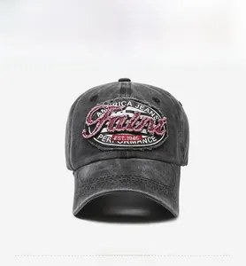 Close-up of vintage washed gray baseball cap with Faini embroidery and frayed edge patch