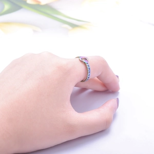 Close-up of adjustable colorful crescent moon ring worn on finger with nature background