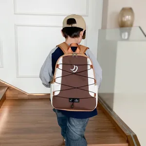 Detail of color-block kids backpack featuring moon print and elastic bungee cords