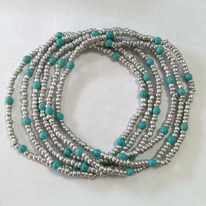 Detail of handmade beaded bracelet featuring silver beads and turquoise stones