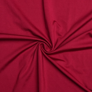 Vue détaillée du tissu rouge lisse montrant sa texture élastique et son drapé