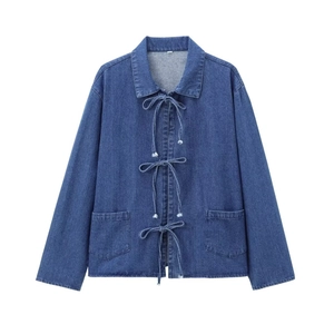 Veste en jean bleue avec trois nœuds papillon et poches plaquées sur fond blanc épuré