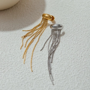 Macro shot of minimalist gold and silver fringe earrings with metallic tassel chains