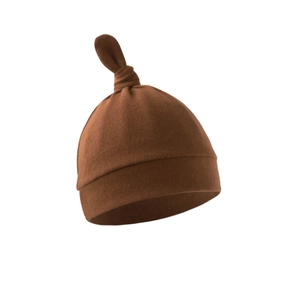 Detail of soft brown knitted newborn hat with a stylish top knot on white background