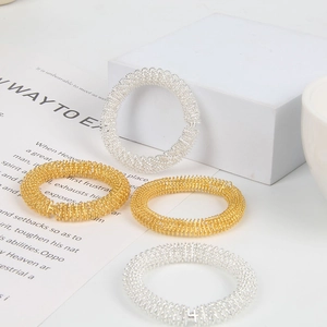 Macro shot of silver and gold spring rings for acupressure on a white aesthetic background