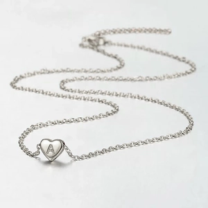 Macro shot of silver stainless steel heart pendant with engraved letter A on fine chain