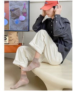 Male model wearing beige mesh cotton ankle socks in a cozy lifestyle indoor setting