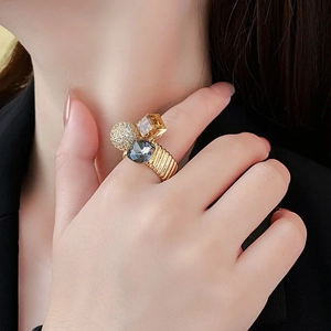 Detail of gold plated ring with zircons and textured band worn on index finger