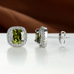 Macro shot of square emerald zircon halo stud earrings with silver metal backing