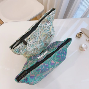 Detail of jacquard makeup bags with traditional dragon and floral patterns and zipper