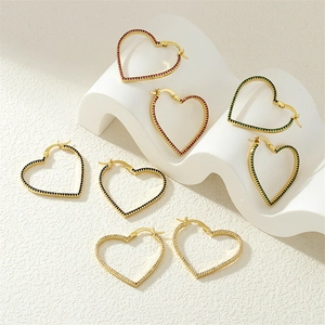 Macro detail of heart-shaped hoop earrings with colorful cubic zirconia in gold setting