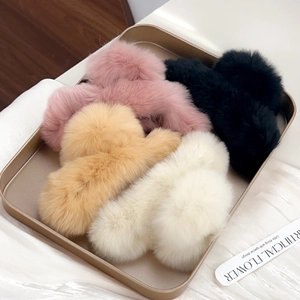 Soft faux fur hair clips in pink, black, khaki and white on a metal tray