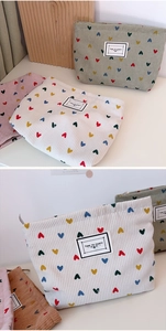 Detailed view of corduroy cosmetic bags with heart patterns and Time to Party labels