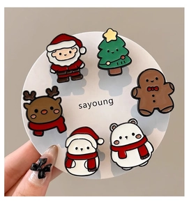 Vue macro d'un ensemble de broches de Noël avec le Père Noël et un renne sur carte blanche