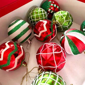 Close-up of assorted red, green and white painted Christmas ornaments in a gift box