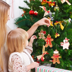 Close-up of gingerbread man and polar bear ornaments hanging on a Christmas tree