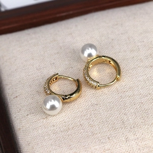 Elegante goldene Creolen mit weißen Perlen und funkelnden Zirkonia-Steinen