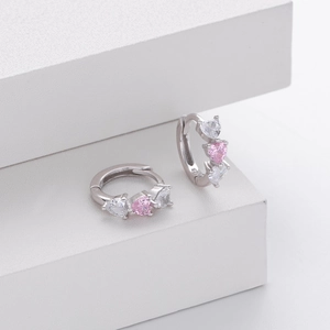 Detail of S925 silver hoop earrings with heart-shaped pink and white zircon stones