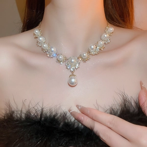 Macro shot of gold floral necklace with pearls and rhinestones on elegant model neck