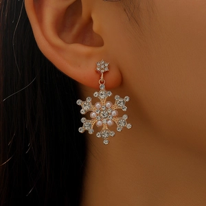 Close-up of snowflake pendant earrings with sparkling rhinestones and white pearls