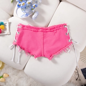 Pantaloncini di jeans rosa con lacci laterali e bordi sfrangiati su sfondo trapuntato