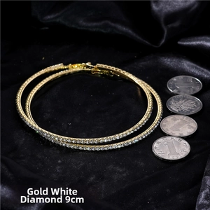 Detailed view of 9cm gold oversized crystal hoop earrings with white rhinestones