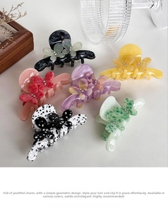 Detail view of floral acetate hair claws in various marble and pastel colors with rhinestones