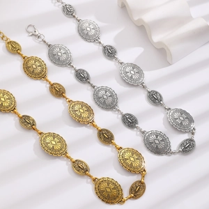 Detail of bohemian metal waist chain with vintage ethnic engravings in gold and silver finish
