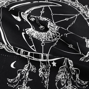 Close-up detail of moon and star dreamcatcher print on bohemian black tapestry fabric