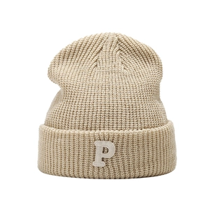 Beanie hat for women featuring a P letter embroidery patch and ribbed knit texture in beige