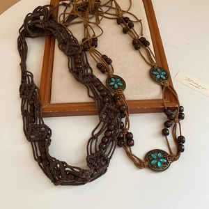 Detail of bohemian braided waist chains with wood beads and turquoise stone inlay