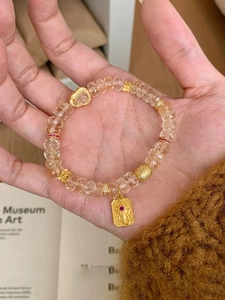 Détail du bracelet en perles de zircon avec pendentif Ganesha doré et gemme rouge