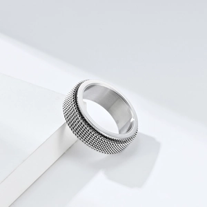 Minimalist silver braided stainless steel spinner ring for men and women on a white stand