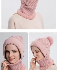 Dettaglio cappello in maglia rosa con fodera in pile e chiusura con bottone decorativo