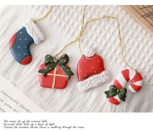 Detail of resin Christmas ornaments featuring a red sock, gift box, hat, and candy cane