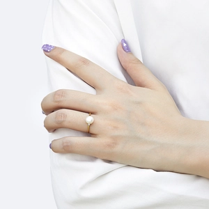 Detail of 925 silver pearl ring with gold plating and zircon stone on woman's hand