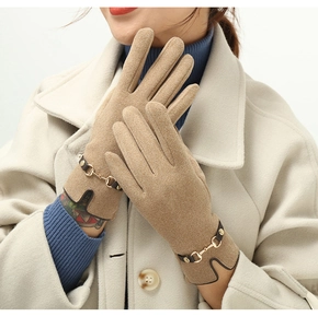 Close-up of khaki winter gloves featuring a gold horsebit buckle and velvet texture