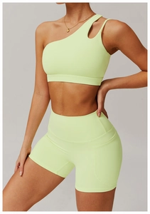 Détail du soutien-gorge de sport asymétrique vert citron et du short de yoga à taille haute