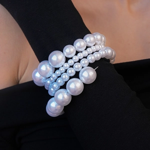 Détail d'un bracelet multi-rangs en perles de différentes tailles sur un poignet
