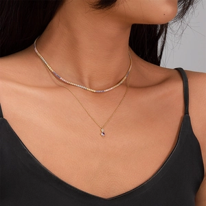 Close-up of layered 925 silver necklaces with colorful zircon and purple heart pendant