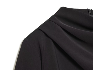 Detail of elegant black pleated shoulder design and high neck with invisible zipper