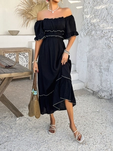 Detail of bohemian black cold-shoulder vacation dress with white ruffled hem accents
