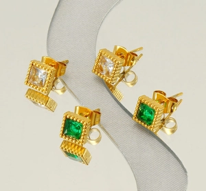 Macro shot of gold-plated stainless steel earrings with square green and clear zircon stones