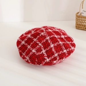 Gros plan détaillé du béret en tweed à carreaux rouges et blancs avec texture tissée